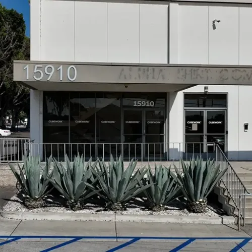 Visible The image shows a solitary grey concrete wall prominently positioned against a neutral background, suggesting a